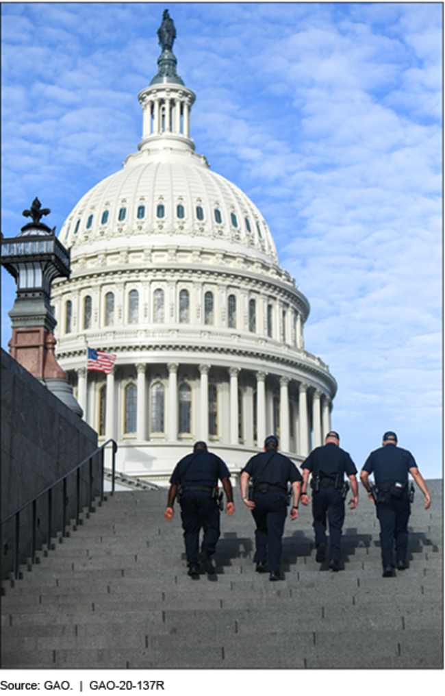 Four police officers walk up steps in front of the United States Capitol
