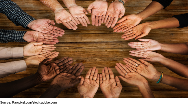An image of hands gathered together in a circle. 