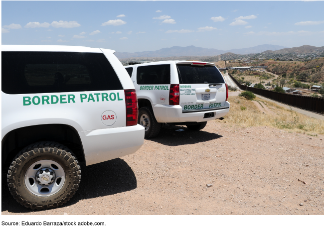 Border Patrol vehicles on a dirt road