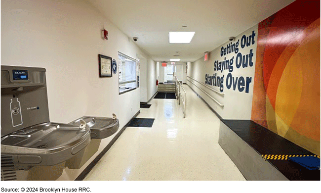 Hall with a door, a ramp, a window and water fountains. The words getting out, staying out, and starting over on the wall. Hall with a door, a ramp, a window and water fountains. The words getting out, staying out, and starting over on the wall.