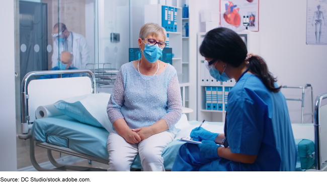A health care professional and a patient in a hospital room