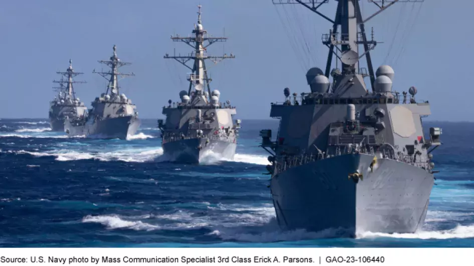 Photo showing 4 grey U.S. Navy ships all in a line in the ocean.