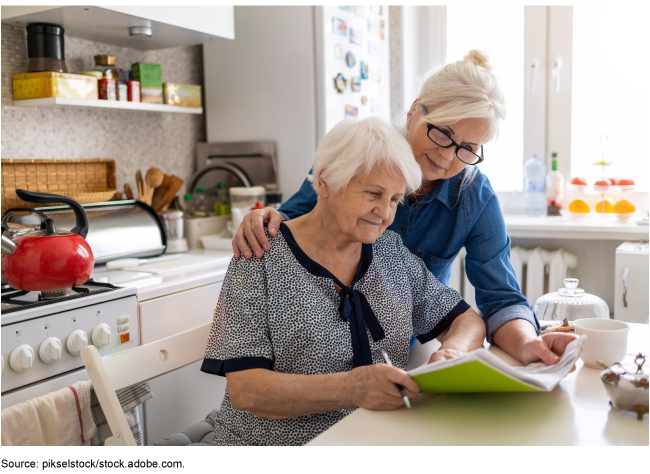Two elderly women reviewing papers.