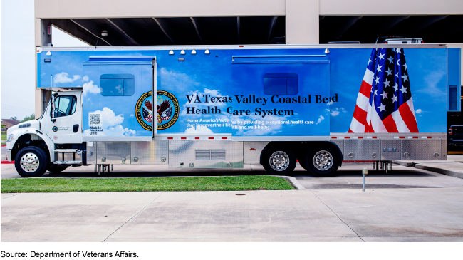 A mobile medical unit--a big truck and trailer with the VA logo and U.S. flag on the side.