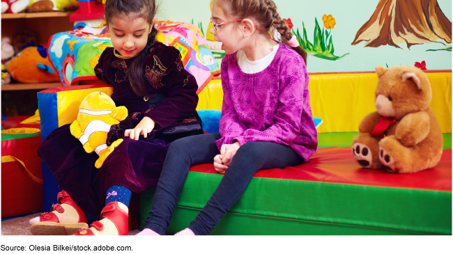 Photo showing two little children playing in a child care classroom setting.