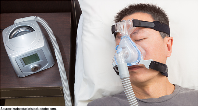 Man sleeping with sleep apnea CPAP machine