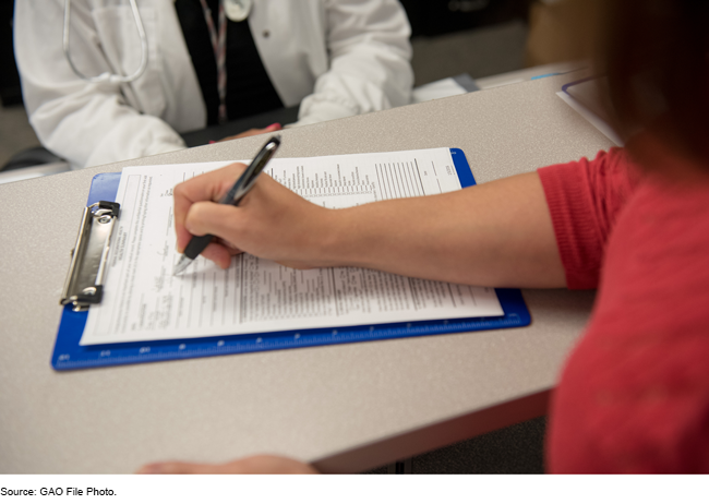 A person fills out a form in a healthcare setting.