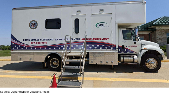 A parked VA mobile medical truck with removable metal stairs leading up to a door in the truck.