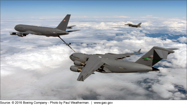 One aircraft refueling another aircraft mid-flight, above the clouds