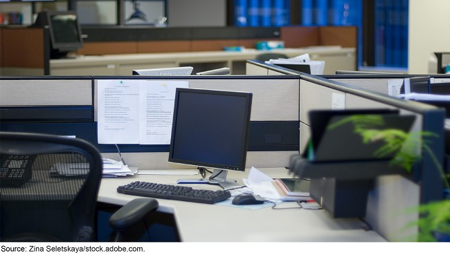 An empty cubicle with a computer in it. An empty cubicle with a computer in it.