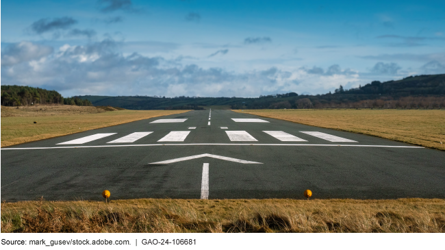 An airplane runway surrounded by a field.