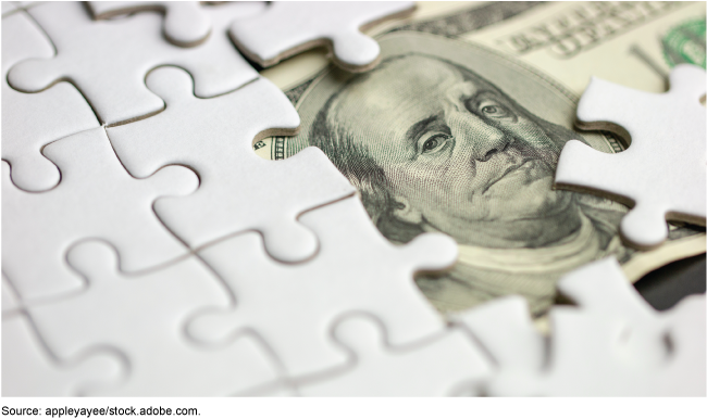 Blank white puzzle pieces partially covering a US 100 dollar bill Blank white puzzle pieces partially covering a US 100 dollar bill