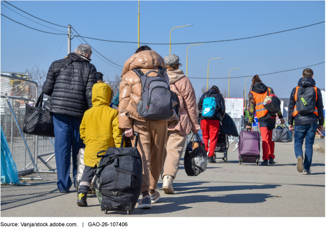 A group of people, including a child, walk away from the camera carrying suitcases and backpacks.