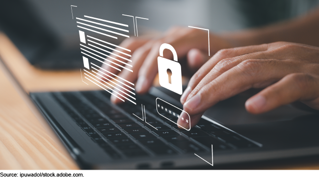 A person typing a password into laptop keyboard with a lock representing data protection. A person typing a password into laptop keyboard with a lock representing data protection.
