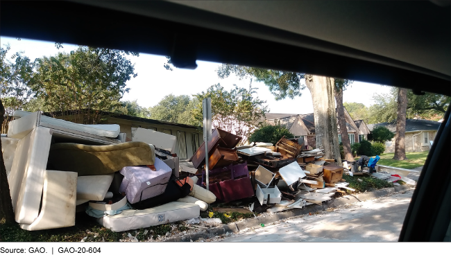 pile of destroyed coaches, mattresses and wood furniture on a curb