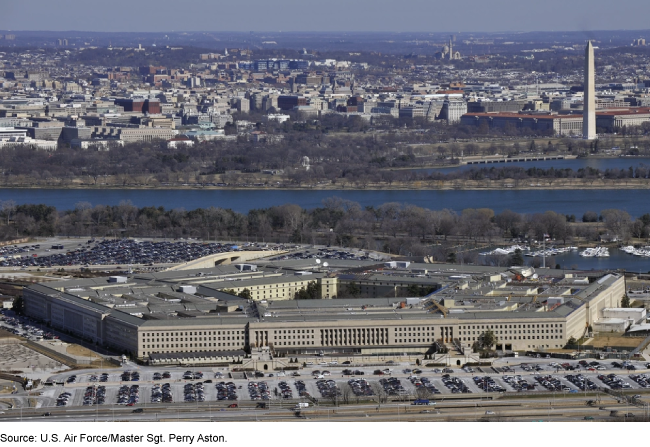 Photo of the Pentagon in Arlington, Virginia taken from above with the Washington, D.C. skyline and Potomac River in the background.