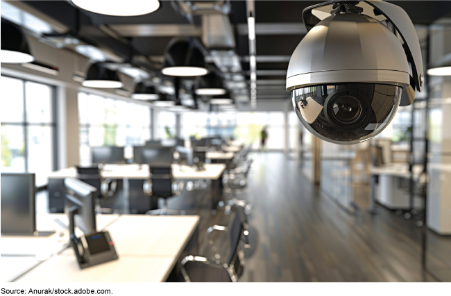 A ceiling-mounted camera with a view of an open floor plan office space. 