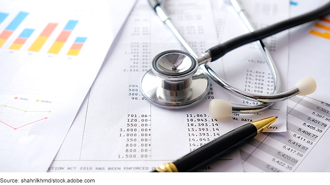 A stethoscope on top of papers with graphs and numbers from bills