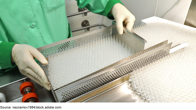 Photo showing someone wearing medical protective gear (gloves, smock) holding a tray of drug testing vials to perform drug quality inspections. 