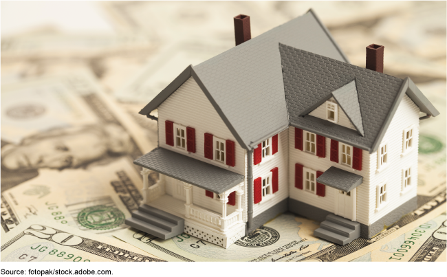 Model of a house on top of U.S. money