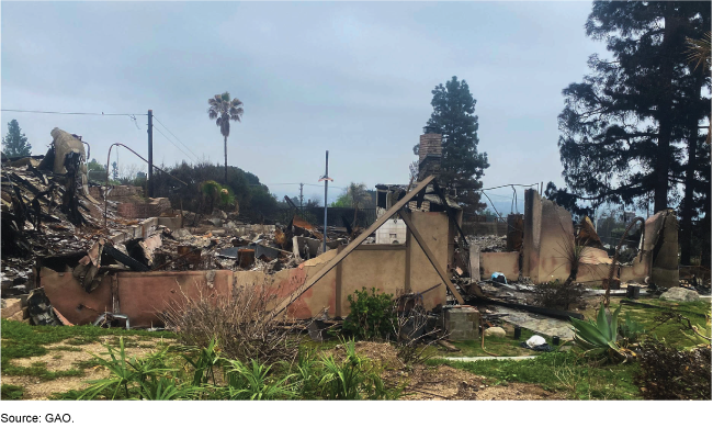 Partial burnt remains of a house’s walls and frames in the aftermath of a fire. Large piles of rubble are in the background. Partial burnt remains of a house’s walls and frames in the aftermath of a fire. Large piles of rubble are in the background.