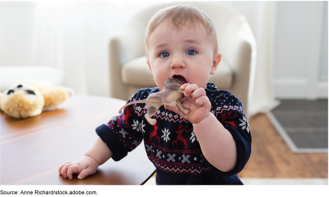 Toddler looking up while opening their mouth to chew on a lion toy. Toddler looking up while opening their mouth to chew on a lion toy.