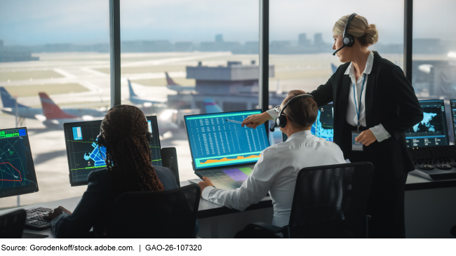 Three air traffic controllers work in an airport control tower.