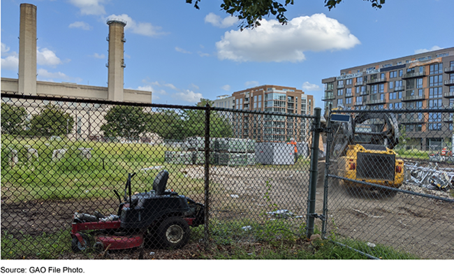 construction equipment on land enclosed by a fence