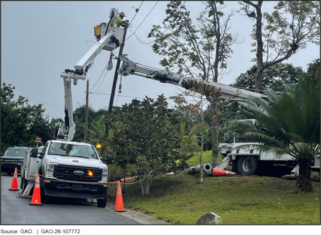 Lineworker standing on bucket truck high in the air, reaches up to a pole while working on replacing it. Lineworker standing on bucket truck high in the air, reaches up to a pole while working on replacing it.