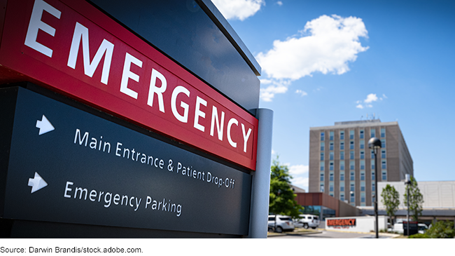 An emergency room sign leading to a parking lot at a hospital An emergency room sign leading to a parking lot at a hospital