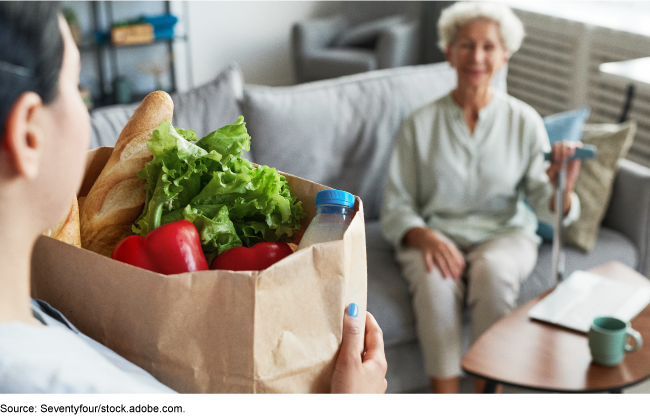 Elderly person receiving a bag of groceries