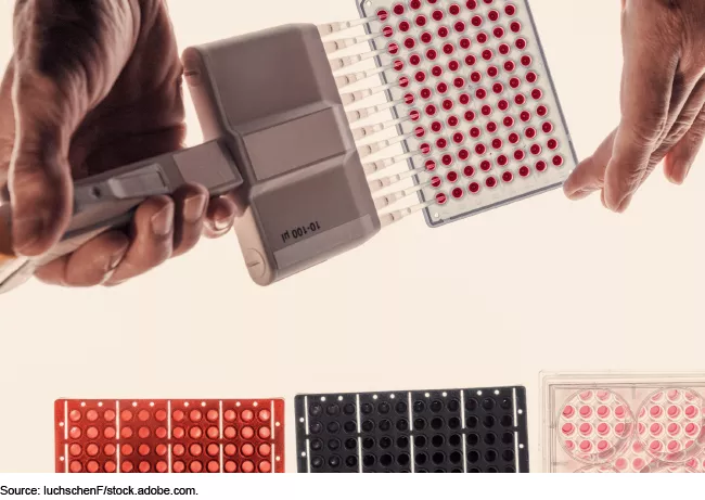 Image of a person using a pipette to fill testing samples. 