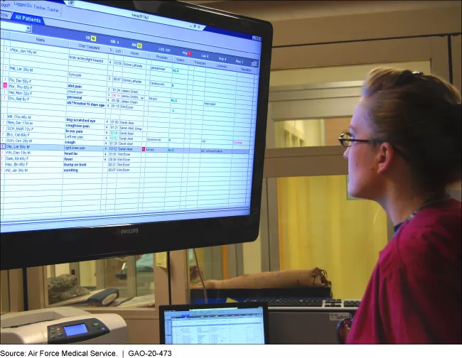 An emergency room nurse reviews the patient status board