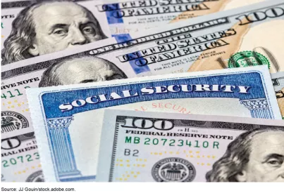 Photo showing a Social Security card lying between $100 dollar bills.
