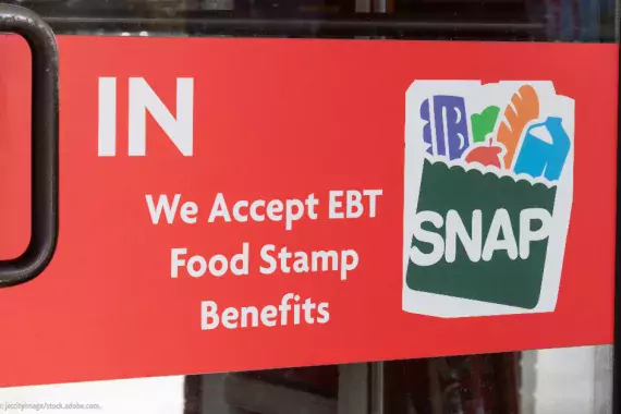 The door to a store with a sign that reads &quot;We accept EBT Food Stamp Benefits--SNAP&quot;