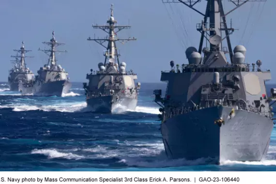 Photo showing 4 grey U.S. Navy ships all in a line in the ocean.