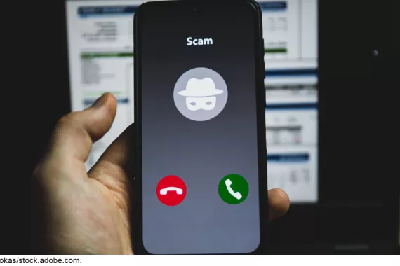 Illustration showing a cellphone in someone's hand. There's an incoming call labeled &quot;SCAM.&quot;