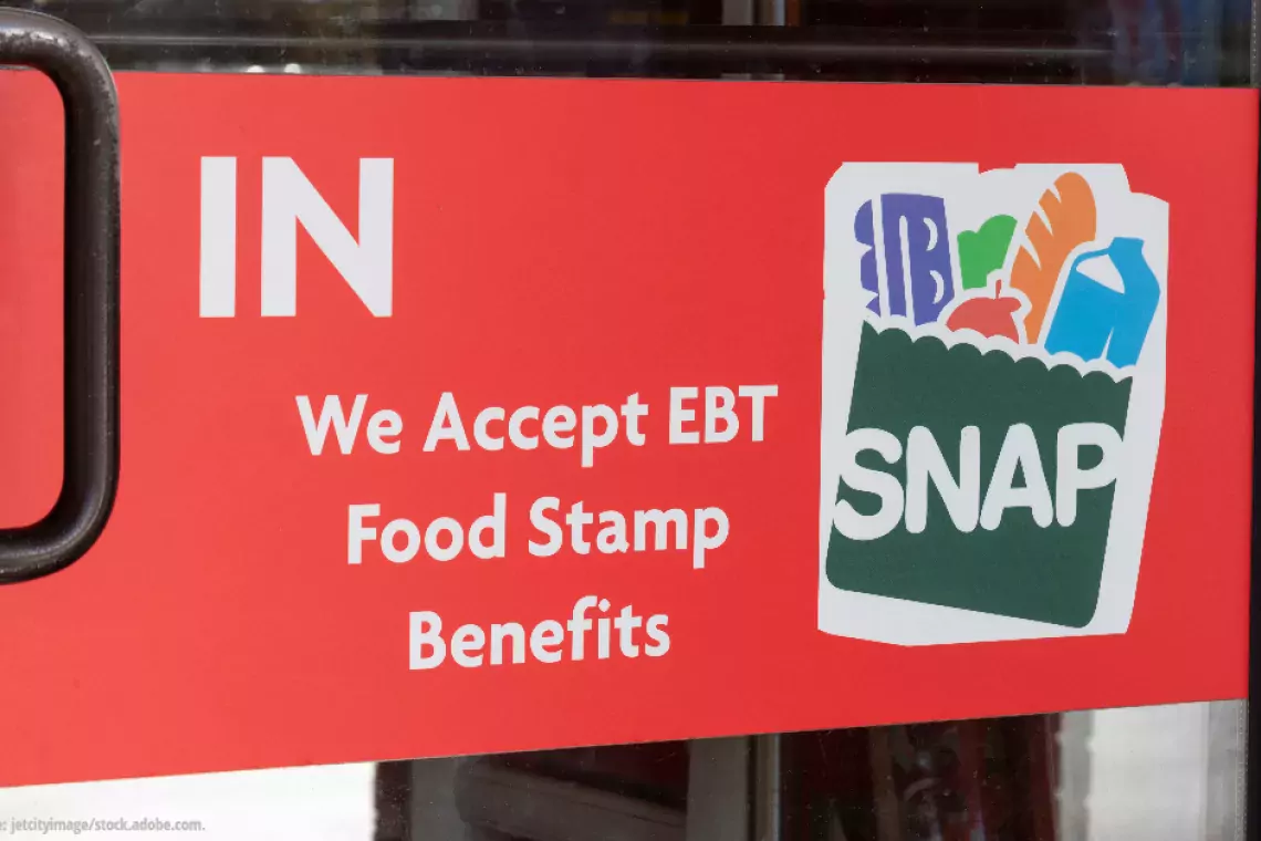 The door to a store with a sign that reads &quot;We accept EBT Food Stamp Benefits--SNAP&quot;